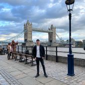 Young student standing in a bay area with the London bridge in the background